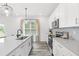 Modern kitchen with white cabinets, quartz countertops, stainless steel appliances and a window overlooking the yard at 3378 Pepperpike Ct, Loganville, GA 30052