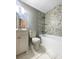 Updated bathroom with marble style tiling on the walls and floor, a tub, and a shower at 2492 Brentwood Ct, Decatur, GA 30032