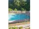 A sparkling community pool is surrounded by a secure black metal fence and lush green foliage at 1041 Kennesborough Nw Rd, Kennesaw, GA 30144