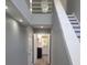 Inviting hallway with staircase and contemporary lighting fixtures leads to bright, open kitchen at 1041 Kennesborough Nw Rd, Kennesaw, GA 30144