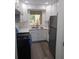 Bright kitchen featuring white cabinets, stainless steel appliances, stone countertops, and wood-look flooring at 1041 Kennesborough Nw Rd, Kennesaw, GA 30144