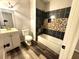 Updated bathroom with modern vanity, toilet, and stone shower surround at 781 Peyton Nw Ave, Atlanta, GA 30318