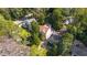 An aerial view shows a home with a brown roof among other houses surrounded by lush trees at 2493 Oldfield Nw Rd, Atlanta, GA 30327