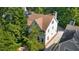 Aerial view of the side and back of the home with a brown roof surrounded by lush green trees and a driveway at 2493 Oldfield Nw Rd, Atlanta, GA 30327