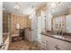 Bright bathroom featuring double vanity with granite countertops, patterned wallpaper, and tiled floors at 2493 Oldfield Nw Rd, Atlanta, GA 30327