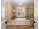 An elegant bathroom with a soaking tub and shower enclosed in decorative tile at 2493 Oldfield Nw Rd, Atlanta, GA 30327