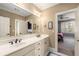 Bathroom with double vanity, large mirror, white cabinets, and a view to the bedroom at 2493 Oldfield Nw Rd, Atlanta, GA 30327