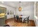 Sunlit dining area with hardwood floors, a modern light fixture, and views of the surrounding landscape at 2493 Oldfield Nw Rd, Atlanta, GA 30327