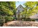 Charming two-story home with stone steps leading to the green front door and a large pea gravel driveway at 2493 Oldfield Nw Rd, Atlanta, GA 30327