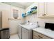 Bright laundry room featuring a front-load washer and dryer, utility sink and patterned wallpaper at 2493 Oldfield Nw Rd, Atlanta, GA 30327