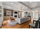 Spacious living room with a stone fireplace, hardwood floors, a gray sofa, and bright natural light at 2493 Oldfield Nw Rd, Atlanta, GA 30327