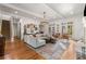 Living room featuring hardwood floors, a gray sofa, a stone fireplace, and many windows for natural light at 2493 Oldfield Nw Rd, Atlanta, GA 30327