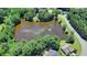Aerial view of a neighborhood with a central pond at 3550 Rivers End Pl, Buford, GA 30519