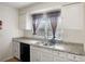 Kitchen boasts granite countertops, white cabinets, and a double sink at 158 Ashwood Ct, Riverdale, GA 30274