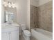 Bright bathroom featuring a tiled shower and a single sink vanity with a marble countertop at 4455 Ryker Rd, Cumming, GA 30041