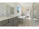 Elegant bathroom featuring double sinks, large mirrors, a soaking tub, and a glass shower at 4455 Ryker Rd, Cumming, GA 30041