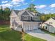 New home showing driveway, three-car garage, brick and siding exterior and manicured lawn at 4455 Ryker Rd, Cumming, GA 30041