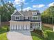 New construction home boasting a three-car garage, brick and siding exterior and manicured front lawn at 4455 Ryker Rd, Cumming, GA 30041