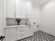 Bright laundry room with white cabinets and geometric floor tile at 1095 Curry Dr, Atlanta, GA 30319