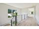 Well-lit hallway with hardwood floors, metal railing, and large windows overlooking the yard at 825 Kenry Ct, Atlanta, GA 30342