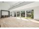 Bright living room with hardwood floors, a balcony and grand windows displaying outdoor landscaping at 825 Kenry Ct, Atlanta, GA 30342