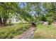 Scenic backyard featuring a gentle stream, a rustic bridge, and verdant landscaping for a tranquil escape at 104 Streambank Ct, Temple, GA 30179