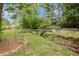Expansive backyard with a quaint bridge, providing access to a lush and private oasis at 104 Streambank Ct, Temple, GA 30179