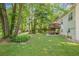 Lush backyard featuring mature trees, a deck with an umbrella and table set, and a storage shed, ideal for relaxation at 104 Streambank Ct, Temple, GA 30179