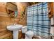 Rustic bathroom showcases wood paneling, stylish fixtures, and a tiled shower-tub, blending charm with functionality at 104 Streambank Ct, Temple, GA 30179