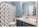 Charming bathroom with a shower featuring a decorative curtain and vanity with sink, blending style and functionality at 104 Streambank Ct, Temple, GA 30179