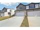 View of newly built townhomes with attached garages, concrete driveways and manicured lawns under sunny blue skies at 270 Bald Ave # 59, Stockbridge, GA 30253