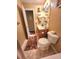 Bathroom features wood vanity, sink, toilet, tile flooring, and an open door at 6561 Harrington Pl, Douglasville, GA 30135