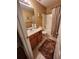 Bathroom features wood vanity, sink, toilet, and shower with tan tile at 6561 Harrington Pl, Douglasville, GA 30135