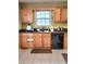 Kitchen with wood cabinets, dark countertops, and black appliances at 6561 Harrington Pl, Douglasville, GA 30135