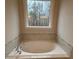 Oval soaking tub with marble tile accents and large window at 3730 Reserve Overlook (Lot 8) Way, Cumming, GA 30041