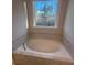 Oval soaking tub with marble-look tile and large window at 3730 Reserve Overlook (Lot 8) Way, Cumming, GA 30041