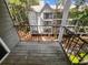 Cozy balcony features wood floors, black metal railing, and a serene view of the wooded surroundings at 311 Granville Ct, Atlanta, GA 30328