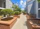Charming condo courtyard featuring landscaped brick planters and mature trees along walking path at 311 Granville Ct, Atlanta, GA 30328