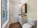 Bathroom with a dark wood vanity, granite countertop, window and toilet with laminate floors at 89 Elsberry Rd, Dallas, GA 30157