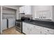 Kitchen view featuring laundry closet, white cabinets, stainless appliances, & breakfast bar at 707 Augusta Se Dr, Marietta, GA 30067