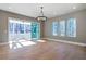 Bright dining room features hardwood floors, sliding glass doors to a porch, and a modern chandelier at 145 Cedarwood Ln, Roswell, GA 30075