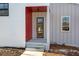 Modern front door with red accent wall and concrete steps at 145 Cedarwood Ln, Roswell, GA 30075