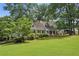 House exterior showcasing a large yard and mature trees at 5622 Williamsburg Dr, Norcross, GA 30093