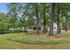 Brick ranch home with a covered porch, surrounded by lush greenery at 5622 Williamsburg Dr, Norcross, GA 30093