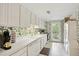Galley kitchen with white cabinets, and access to backyard at 5622 Williamsburg Dr, Norcross, GA 30093