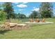 Outdoor seating area with Adirondack chairs arranged around a central fire pit in a manicured common area at 929 Hilltop Park Ct, Dacula, GA 30019