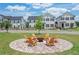 Outdoor seating area with Adirondack chairs arranged around a central fire pit in a manicured common area at 929 Hilltop Park Ct, Dacula, GA 30019