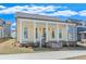 Beautiful yellow home with a covered front porch supported by classic white columns and a well-manicured lawn at 929 Hilltop Park Ct, Dacula, GA 30019