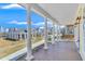 Spacious covered front porch with wooden flooring, elegant white columns, and views of a charming neighborhood at 929 Hilltop Park Ct, Dacula, GA 30019