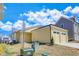 Exterior showcasing the side of a yellow home with a two-car garage and a well-maintained lawn at 929 Hilltop Park Ct, Dacula, GA 30019